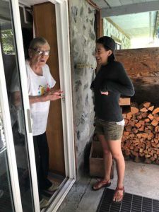 Photo of Gillian and her Granny at their family cabin. Gillian is standing just outside the door and Granny is in the doorway