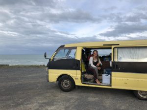 Stephanie in a van on a beach