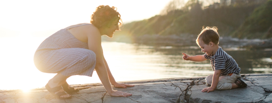 Mother and child playing on a beach at sunset